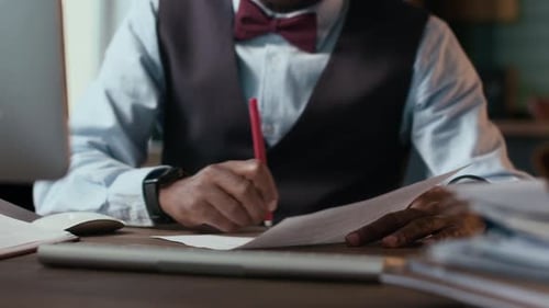 Educational Specialist Marking Students Works at Table Indoors