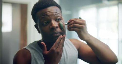Man Using Face Roller for Skincare Routine