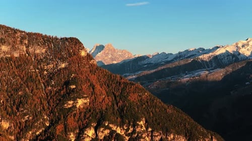 Golden Sunlight Over Fiemme Valley During Autumn In The Italian Dolomites. aerial sideways shot