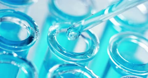 Dans un laboratoire, un scientifique muni d'une pipette analyse un liquide coloré pour en extraire l'ADN et la molécule