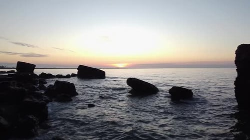 Beautiful vibrant high contrast sunset low altitude flyover over the Karosta war port concrete coast