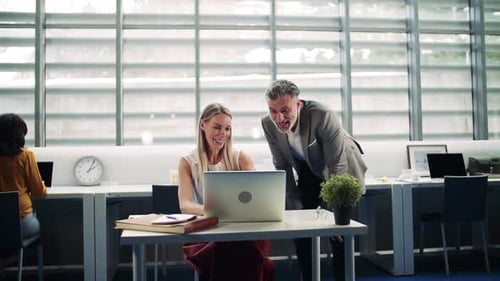 Les hommes d'affaires avec un ordinateur portable au bureau expriment leur enthousiasme