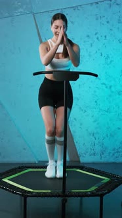 Woman Exercising on Mini Trampoline With Handle