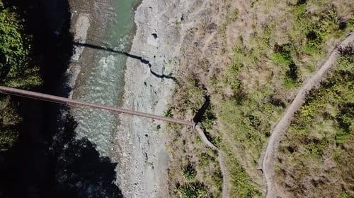 Von oben nach unten folgt eine Metallhängebrücke, die sich über den Mountain River Creek erstreckt und zur Trails