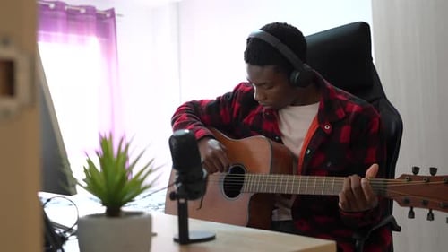 Young musician recording guitar music at home studio