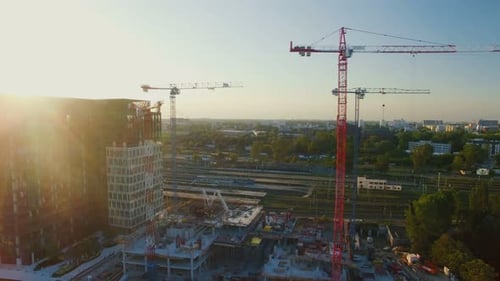 Toma aérea de grúas en un sitio de construcción. El gran paisaje urbano es visible a la luz del sol
.