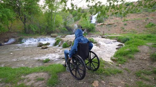 Person in Wheelchair Enjoys River and Waterfall View
