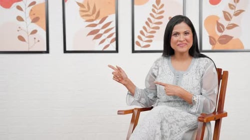 Woman Sitting Pointing to Copy Space