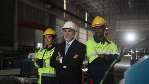 White collar worker and blue collar workers are working together at metal sheet factory.