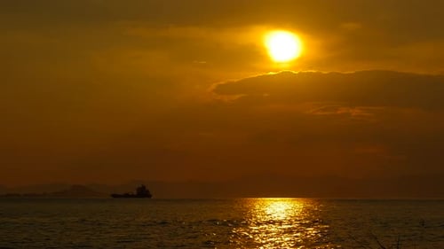 Golden Sunset Over the Ocean with Silhouetted Ship