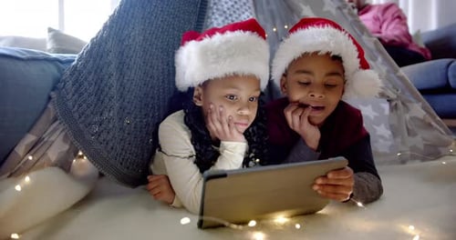 Children in Santa Hats Use Tablet in Fort