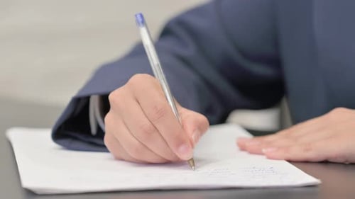Close up of Mixed Race Businesswoman Writing a Letter