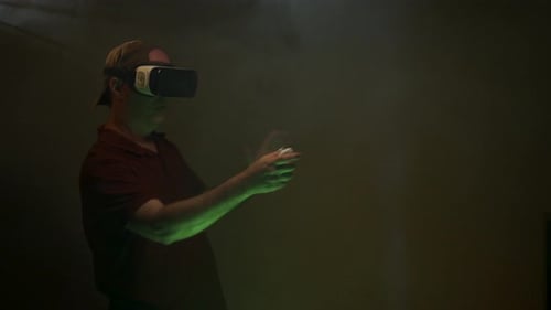 Adult Uses Virtual Reality Headset with Controllers