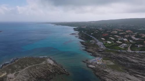 Aerial View of a Sardinian Beach with Turquoise Waters Sandy Shoreline and Beachgoers