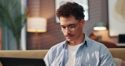 Young Adult Working on Laptop in Living Room