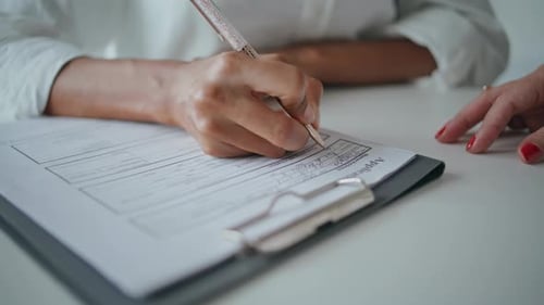 Nahaufnahme, Hände, die Bewerbungsunterlagen auf den Schreibtisch schreiben, Patient unterschreibt Versicherungsformular