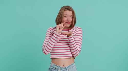 Woman Makes Small Gesture Against Green Screen Backdrop