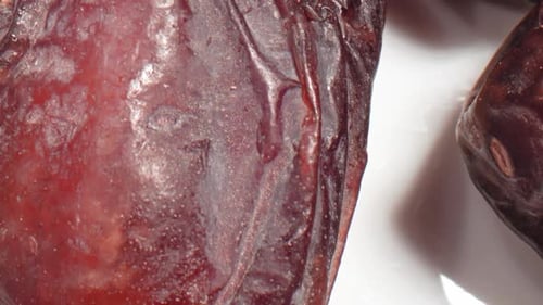 Macro Footage of Dark Brown Dates on White Surface