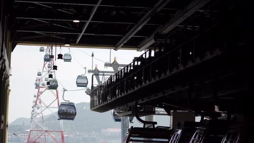 Cable Cars Move Through a Station Close to the Mountains on a Cloudy Day in the City During