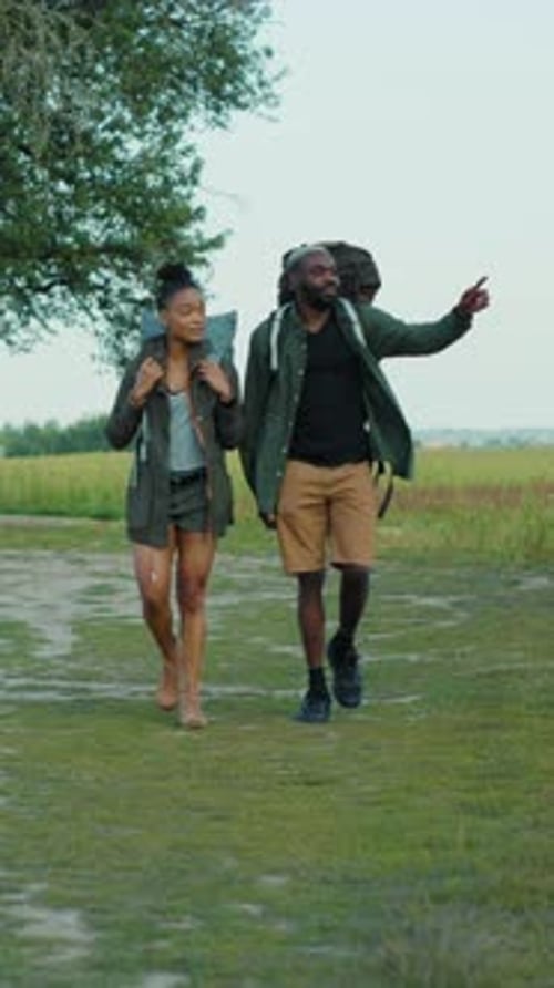 Couple Walking with Backpacks on a Rural Path