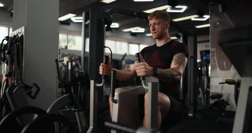 Man Using Seated Row Machine at the Gym