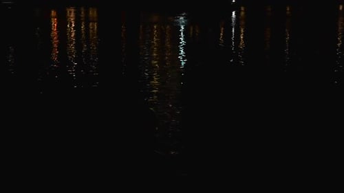 Night River Cityscape reflecting in the Water with moving cars.