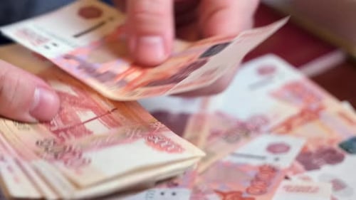 Male hands count Russian money 5000 banknotes