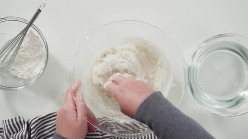 Adding Water and Flour to Dough for Baking