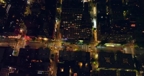 Cars crossing the numerous crossroads. Beautiful well-lit streets of New York at night. Top view.