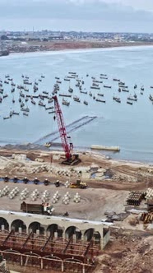 Construction activity near the coast in Accra, Ghana with fishing boats