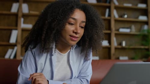 Young Woman Scrolling on Laptop Online