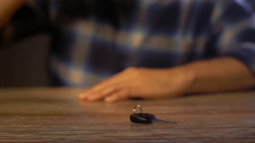 Drunk driver reaches for car key after drinking beer at home or in a bar