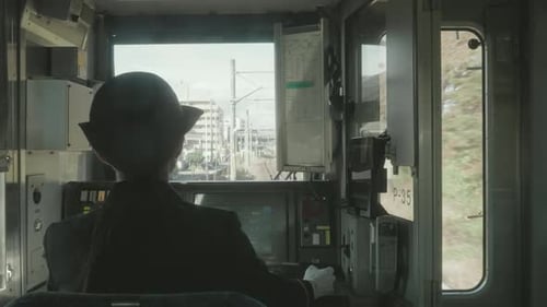 Vue derrière une femme chef d'orchestre dans le compartiment de l'équipage conduisant un train de voyageurs dans la ville de