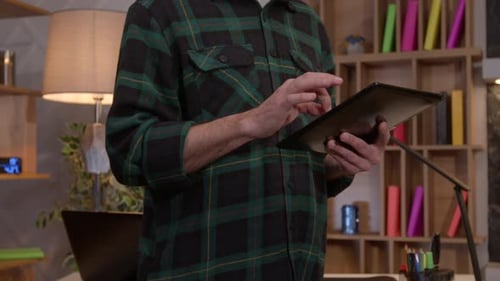 Closeup of Male Hands Browsing Online Content on Digital Tablet at Home Office