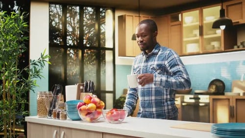 Man drinking from a mug in modern kitchen