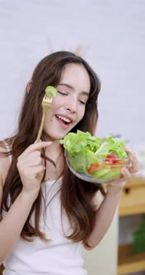 Young Woman Enjoys Eating a Fresh Salad