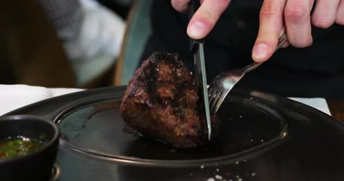 Cutting Juicy Steak with Knife and Fork