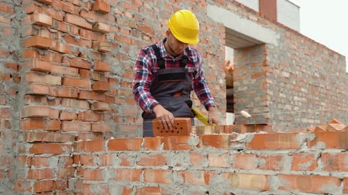 Construction Worker Laying Brick on a Wall