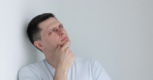 Man Thinking While Leaning on Wall