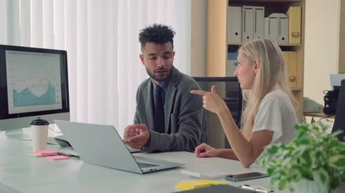 Managers Pointing at Laptop Screen while Discussing Details of New Project