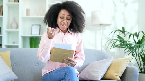 Woman Reads Letter With Expression of Joy