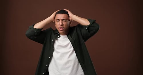 Man Expresses Shocked Worry with Hands on Head