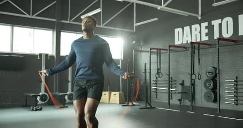 Man, skipping rope and fitness in gym, jumping exercise and cardio workout for strong leg muscles