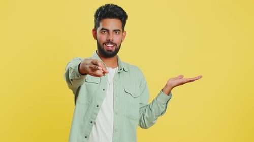 Young Man Showing Thumbs Up and Pointing at Right on Blank Space Place for your Advertisement Logo