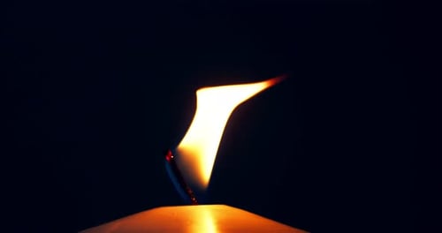 Single white candle burning.Isolated candle burning with dark background.White paraffin candle with