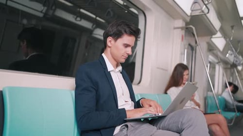 Geschäftsmann, der einen Laptop-Computer im Skytrain oder in der U-Bahn nutzt
