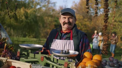 Man Stands Proudly at His Outdoor Fruit Stand