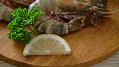 Raw Tiger Prawns with Lemon on Wooden Board