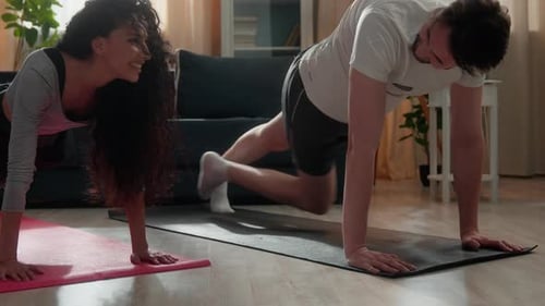 Athletic Couple Doing Mountain Climbers Together at Home