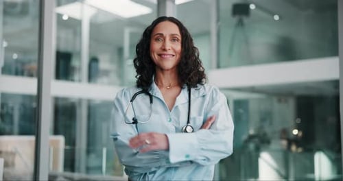 Arms crossed, doctor and smile with woman in hospital for professional healthcare or medical career